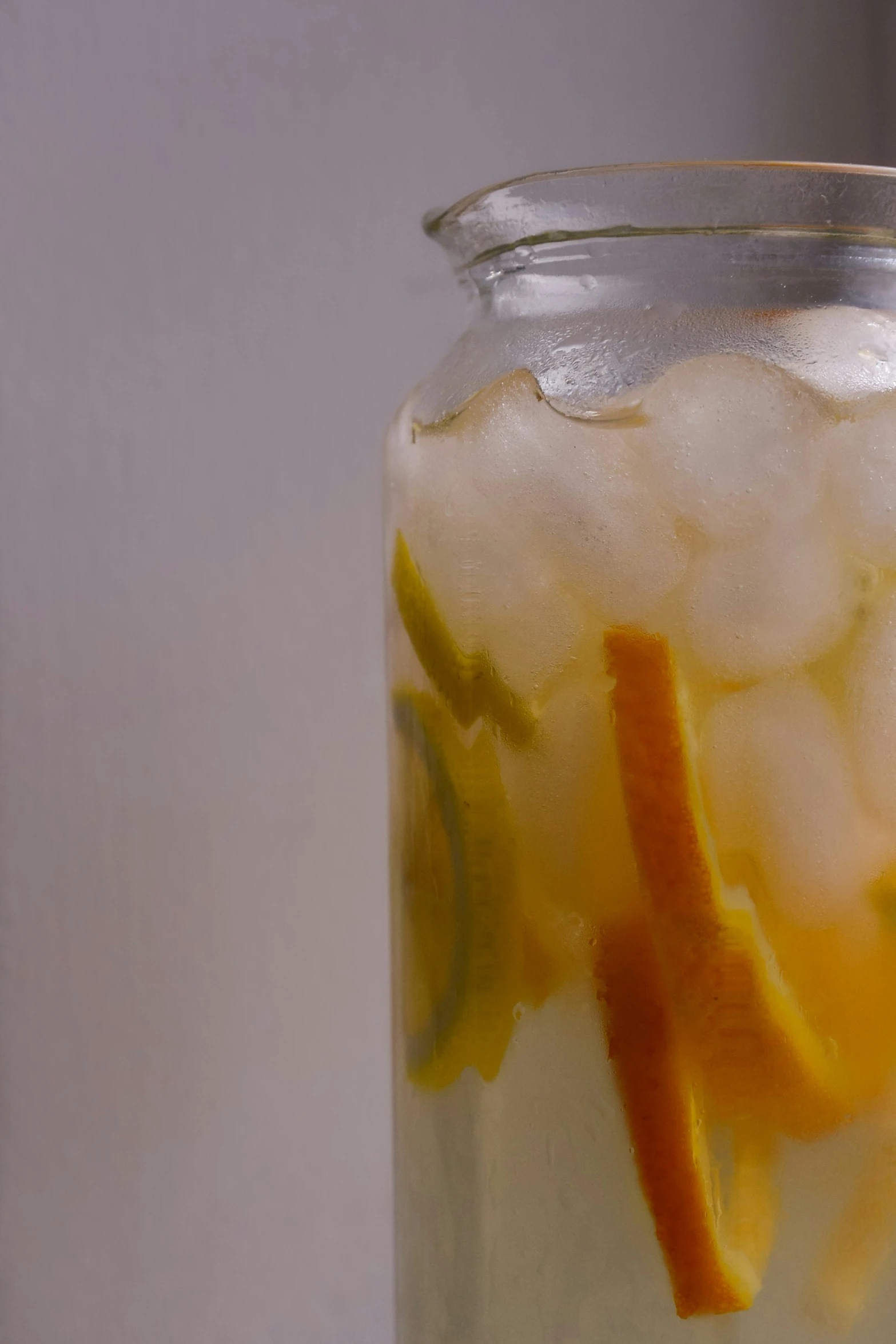 a mason jar filled with liquid and some fruit wedges