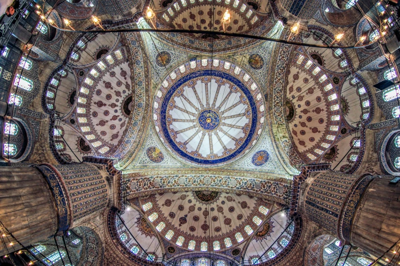 a clock is hanging in a cathedral above other domes