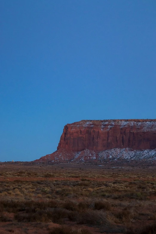 a mountain with a sky background and a horse in the foreground