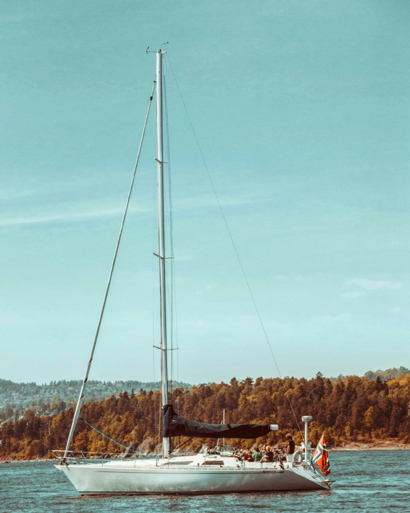 a sailboat with people on it in a body of water