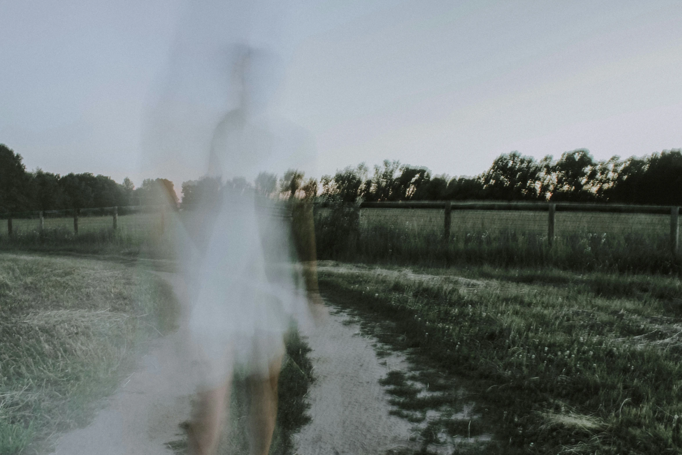 woman walking alone on a path with her long white dress on