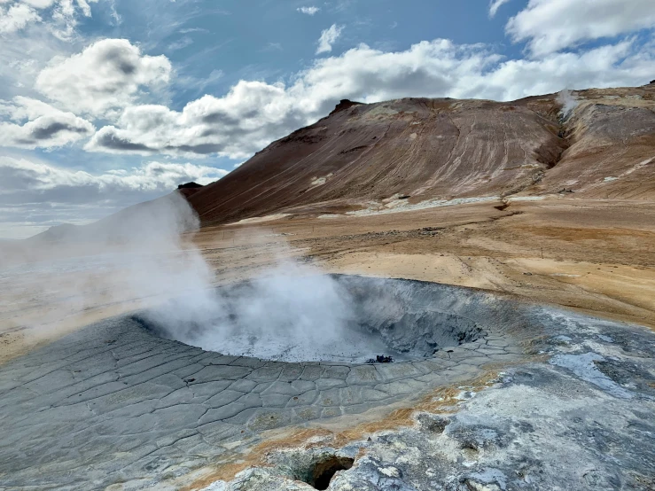 an extremely distant geol scene shows a geyser and rock