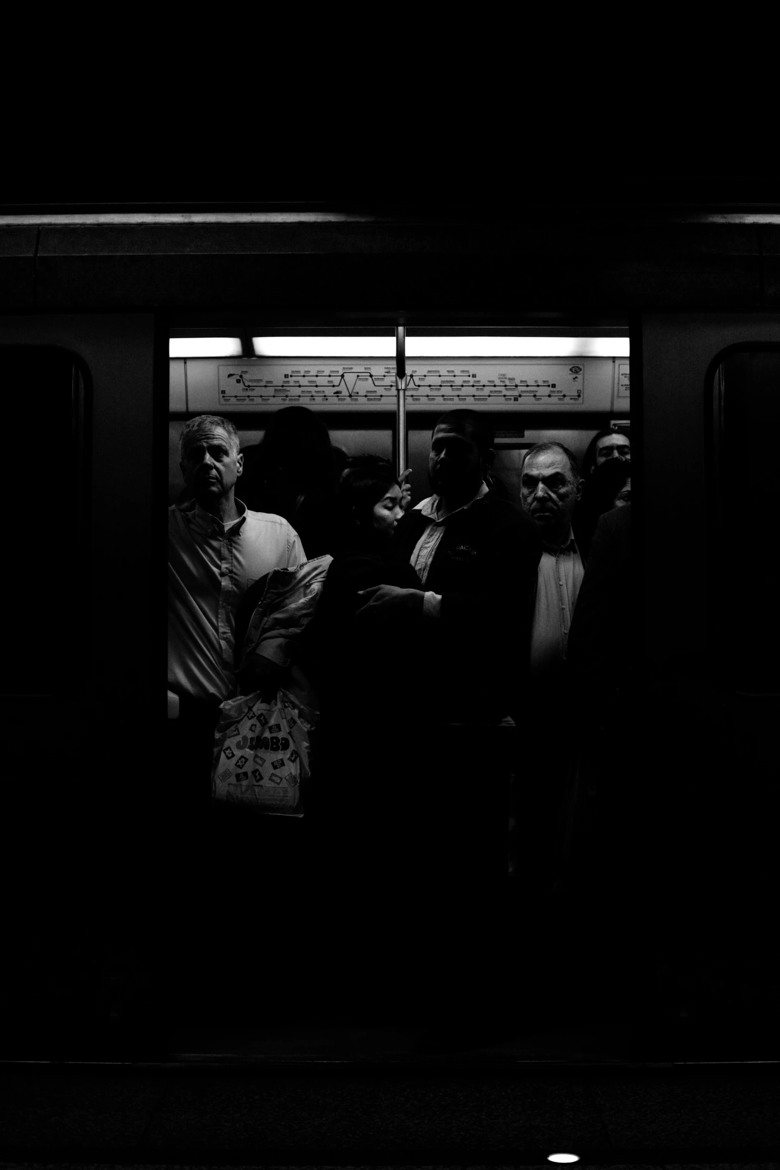 a group of people are sitting inside of a subway