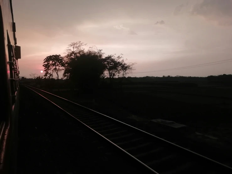 a train traveling down train tracks near trees