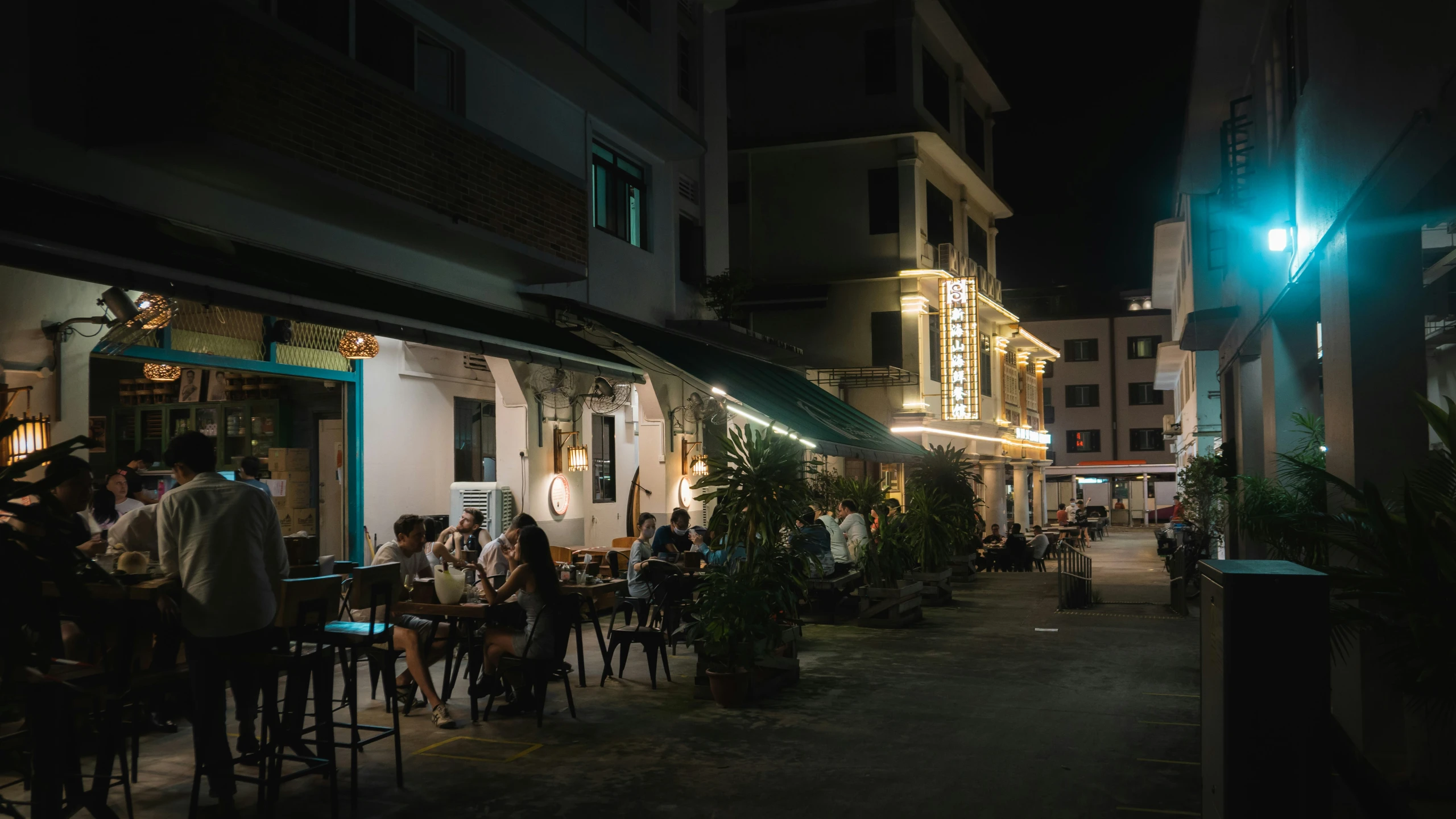 the city at night has many tables, chairs, and lights