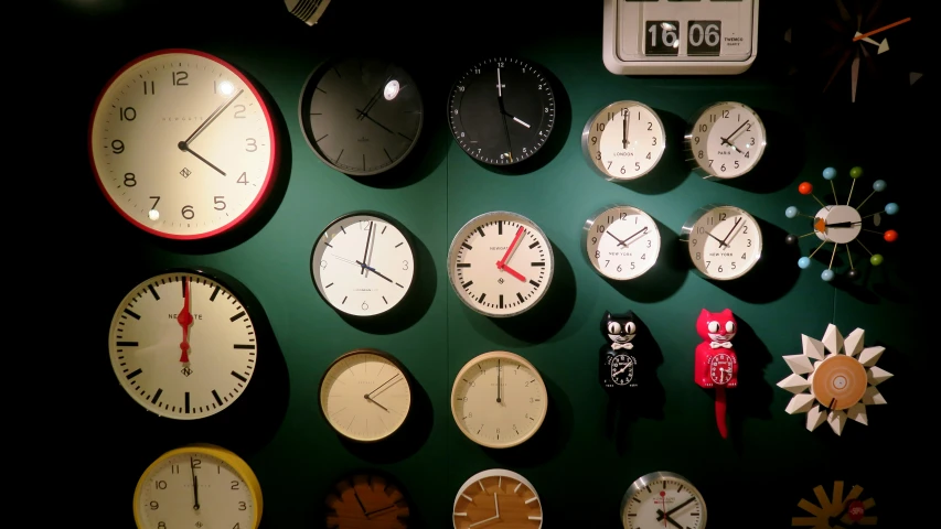 an assortment of clocks hanging up on a wall
