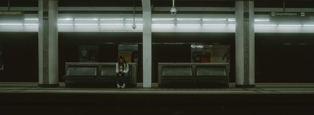 a person standing on a rail near an empty train station