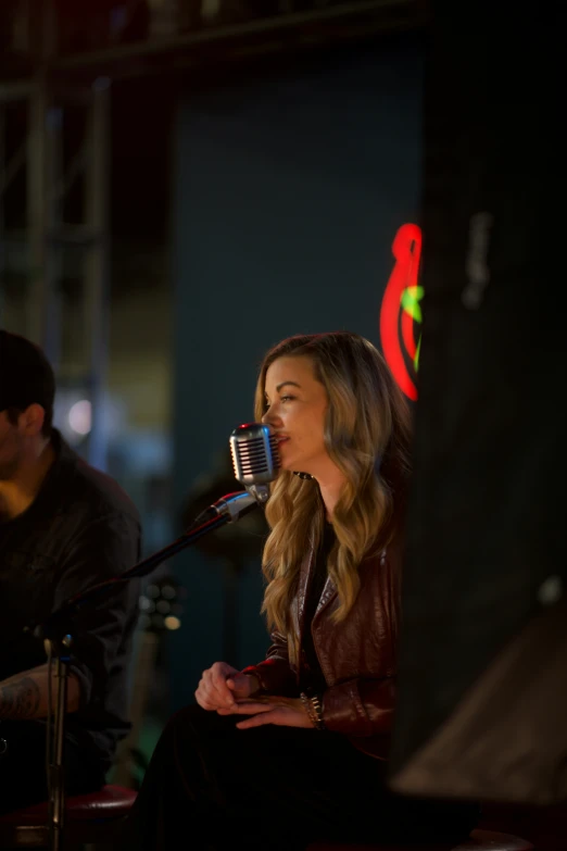 the woman is singing into the microphone with her hand