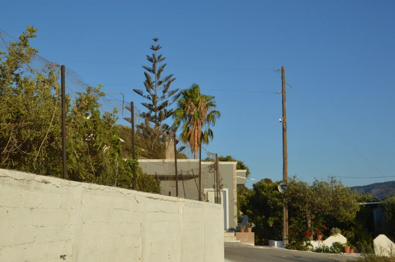 a sign posted in a stone fence and a street