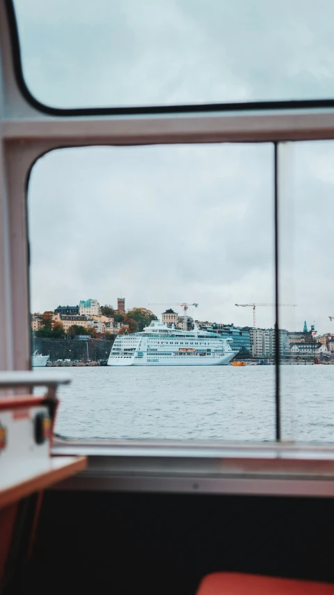 a ship sailing on a river with buildings behind it