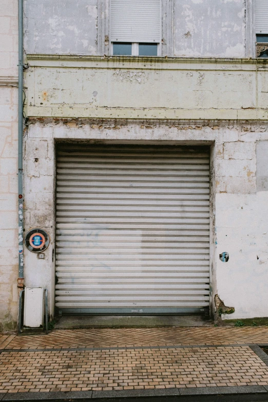 an empty garage with no doors on a brick sidewalk
