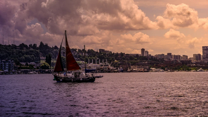 a sailboat on the water with a city in the background