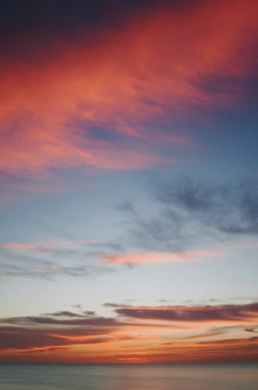 a sunset over the ocean with an orange and pink color