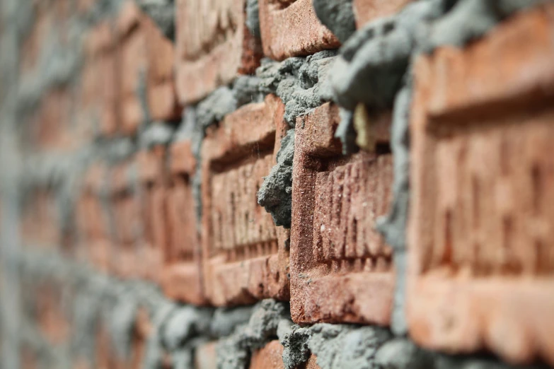 a close up of a brick wall with some mortar blocks