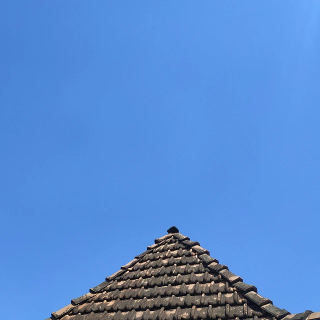 a small plane flying high above a roof