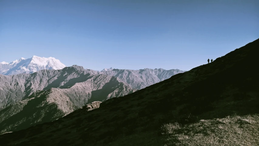 the silhouette of some people on a mountain top