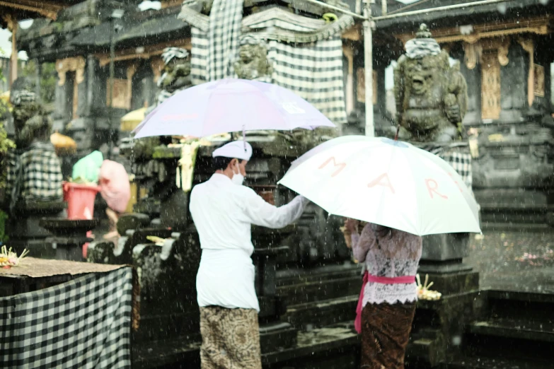 there are people that are holding umbrellas standing outside