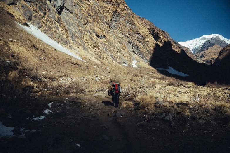 a man hiking up to a mountain in a backpack