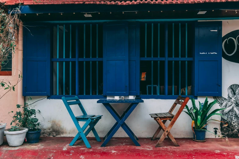 two blue chairs sit outside a cafe on a sidewalk