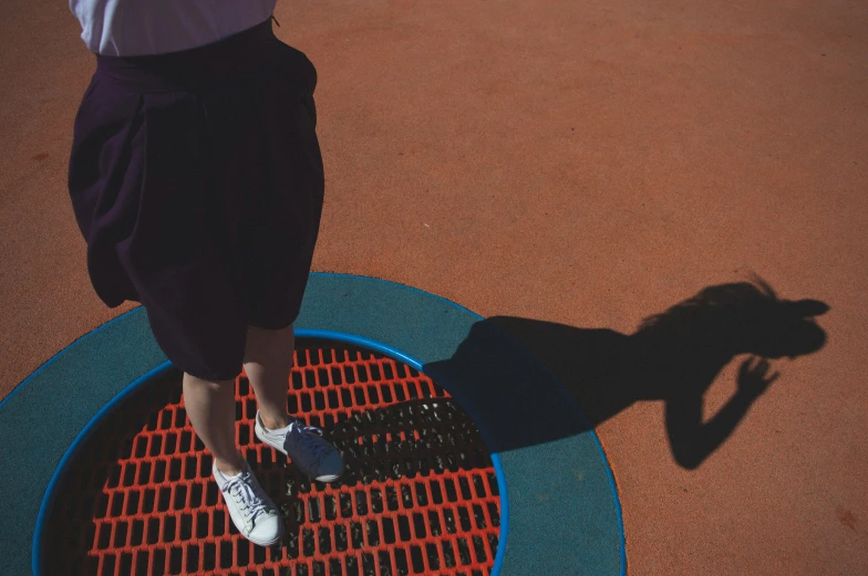 the shadow of a person walking across a tennis court