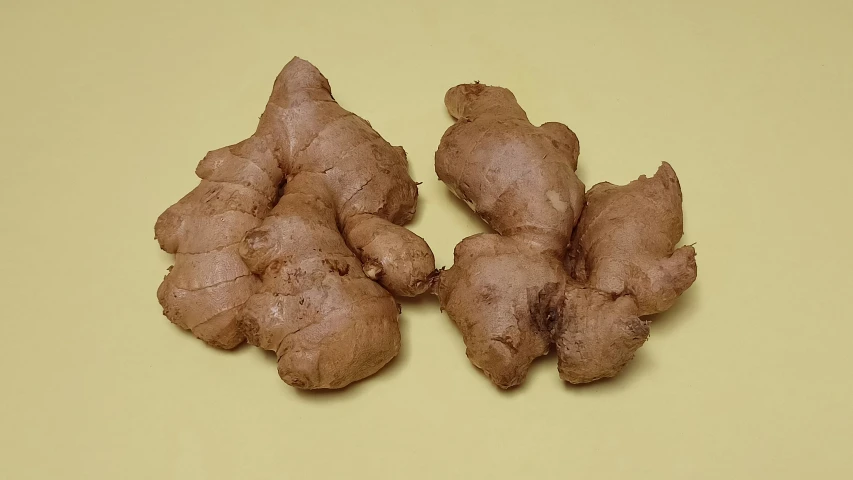 two pieces of ginger on a yellow surface