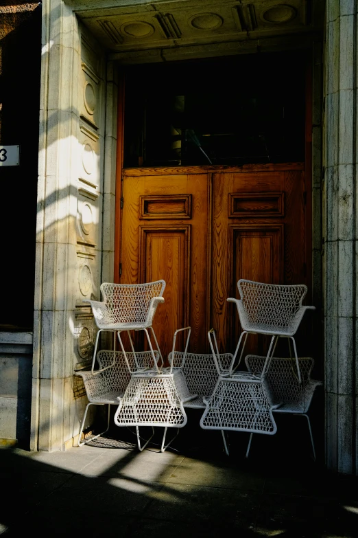 a close up of a group of white chairs in front of a door