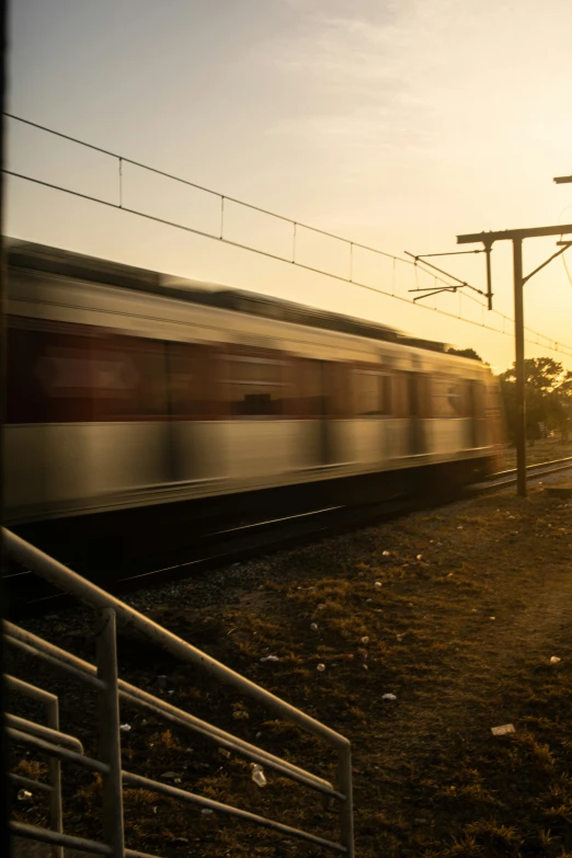 a train going through the countryside during the sunset