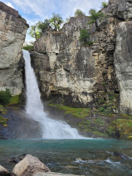 a waterfall flows through some rocks into the water