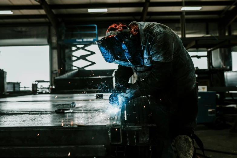 a welder works with a sparks on a steel plate