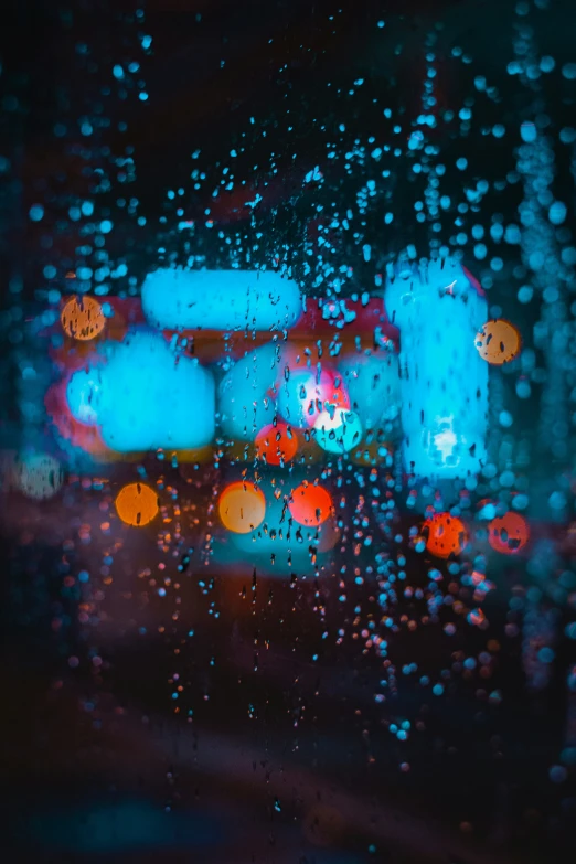 a rain covered window shows cars and traffic