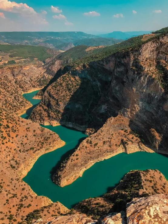 two rivers in a large canyon with mountains in the background