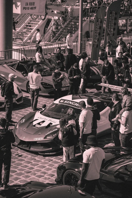 two racing cars sitting next to each other on a tarmac