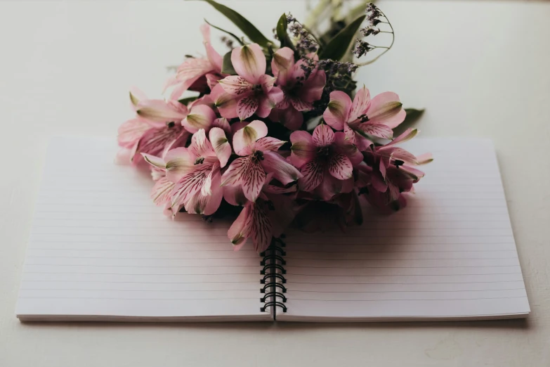 flowers that are on a notebook with a notepad