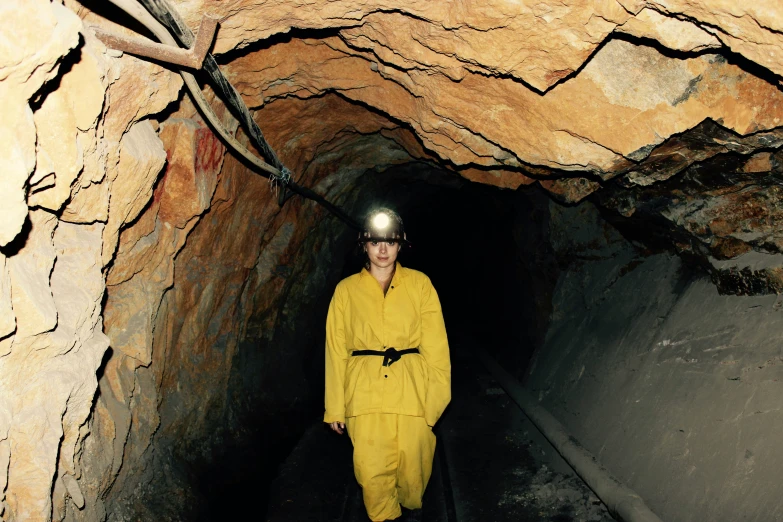 a person in yellow is walking up the tunnel