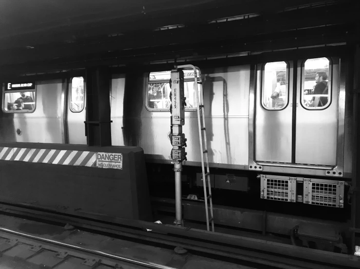 a black and white image of a train sitting next to another train