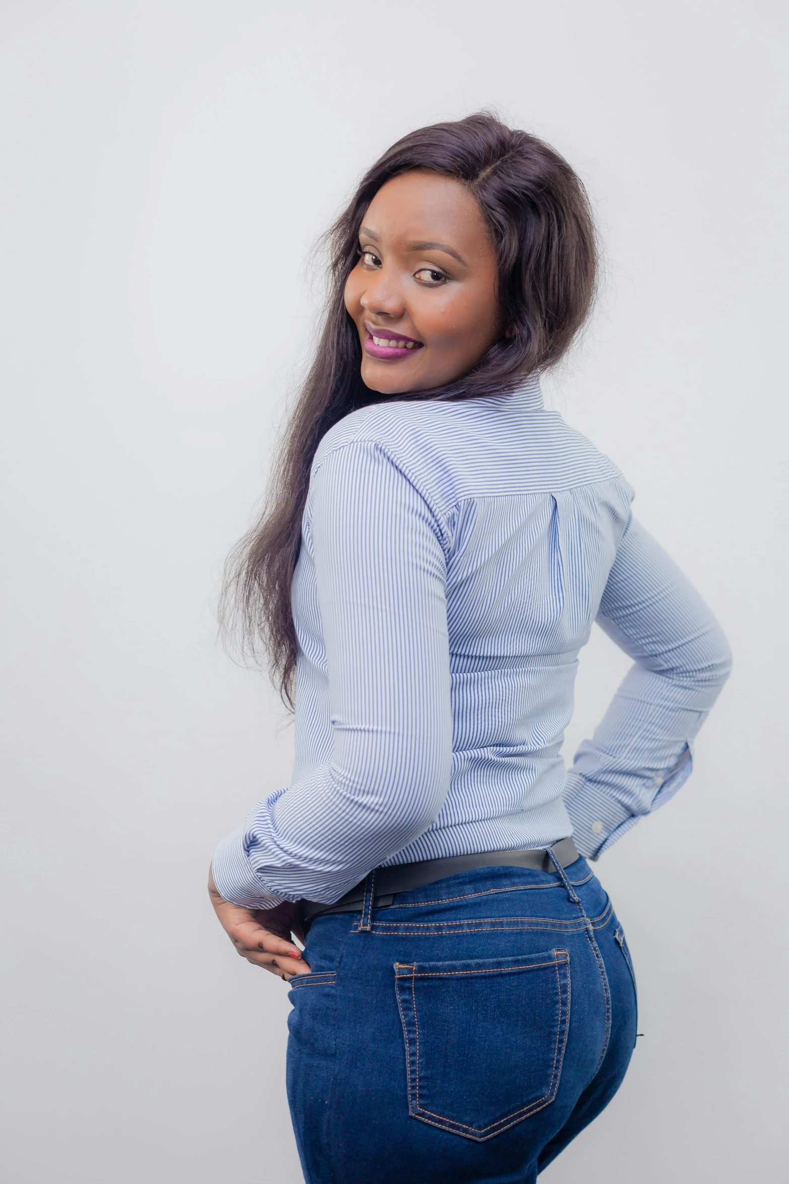 a beautiful woman in high waist jeans posing for the camera