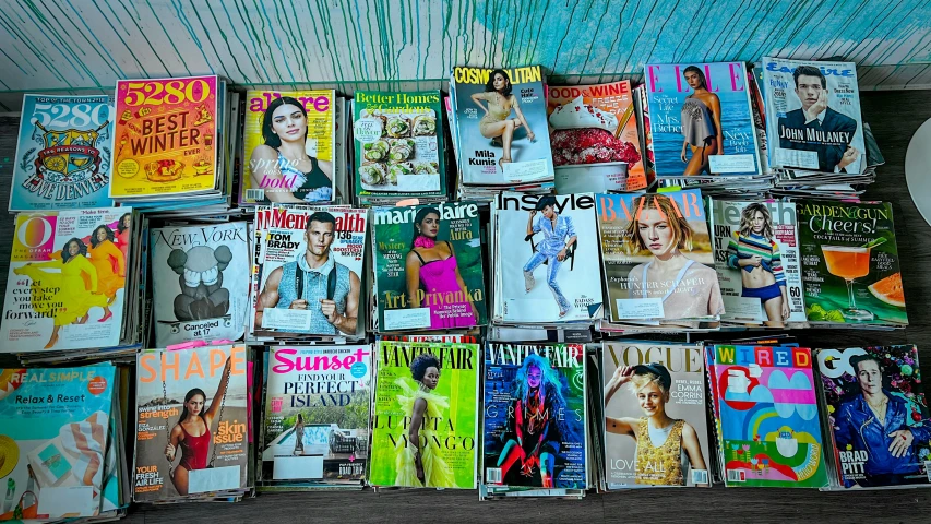 a bunch of magazine covers laying on a shelf