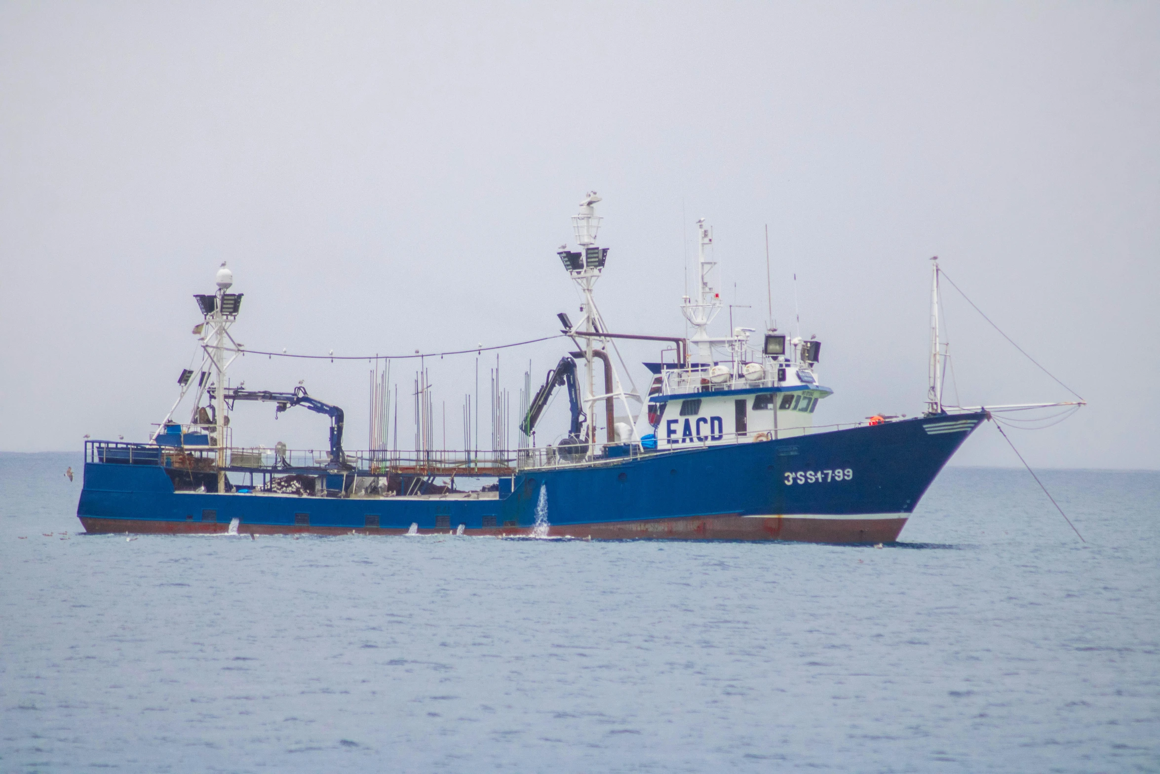 a large fishing vessel is coming in to the dock