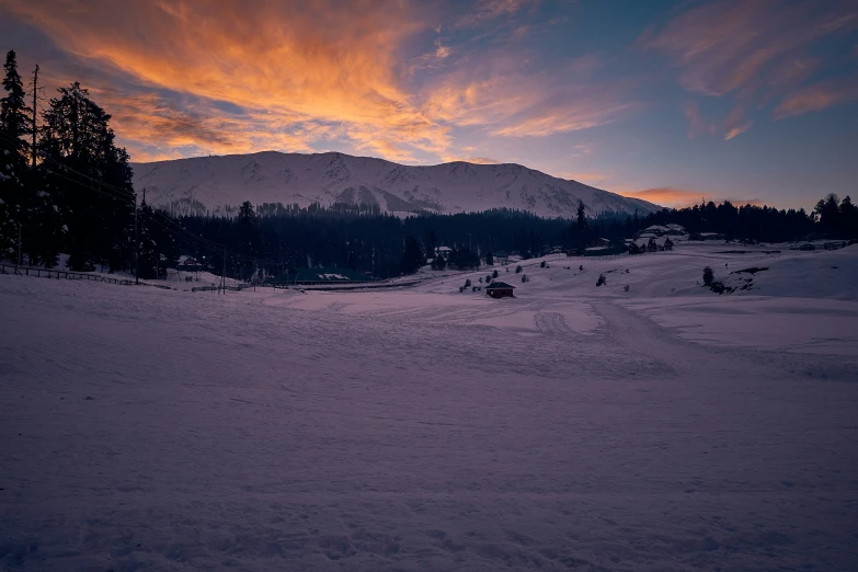 a beautiful sunset over a ski lodge in the mountains