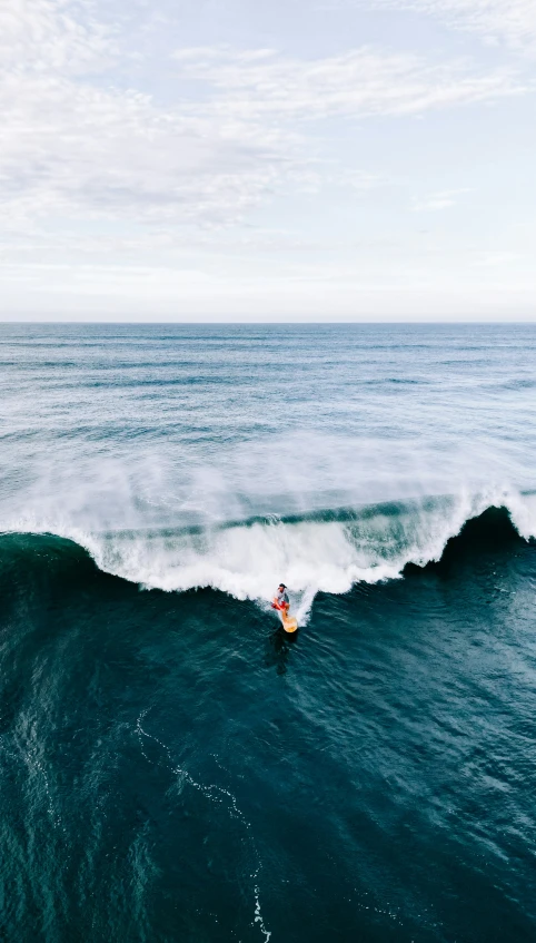 a man riding a wave on top of a surfboard