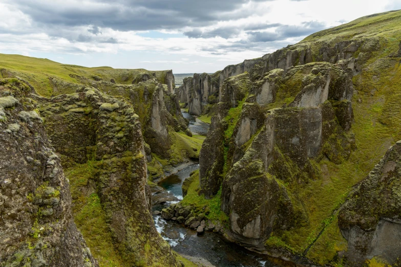 the mountains and river are green and very rocky