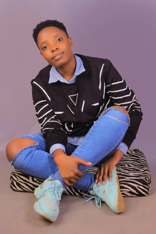 an african boy sitting on the floor and smiling