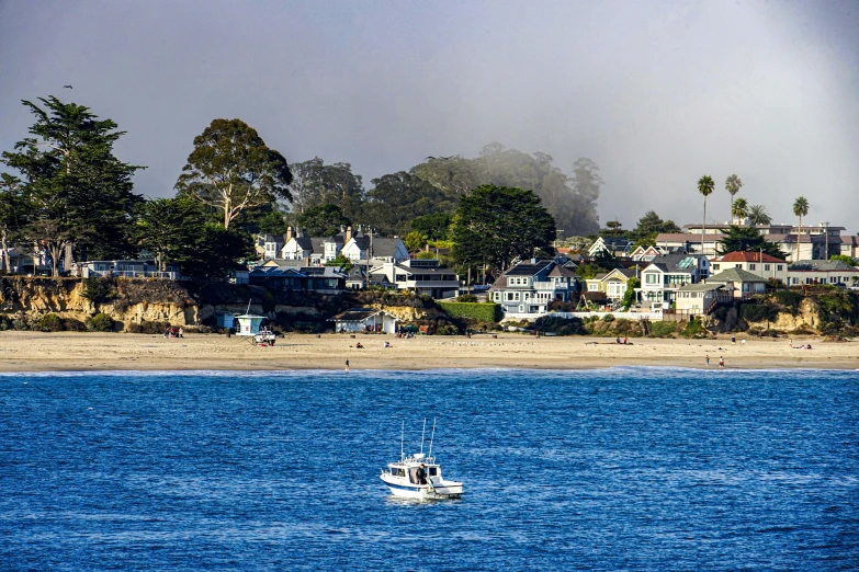 two fishing boats floating on the water near houses