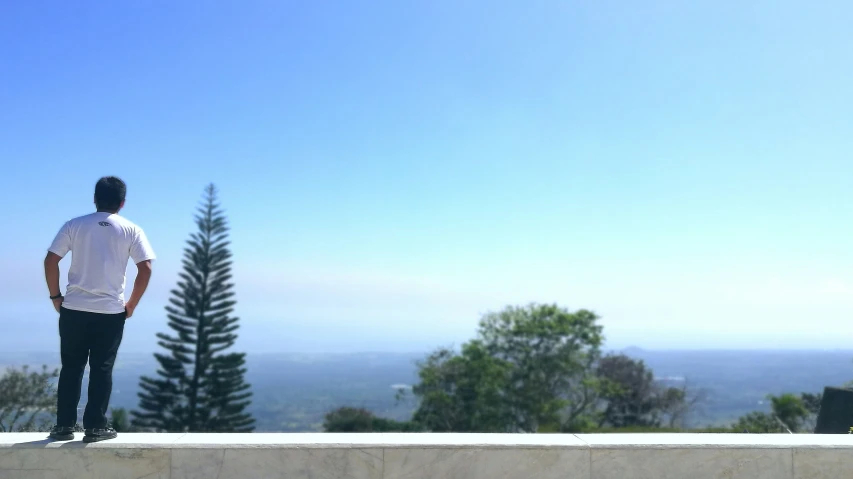 a man standing on top of a cement wall