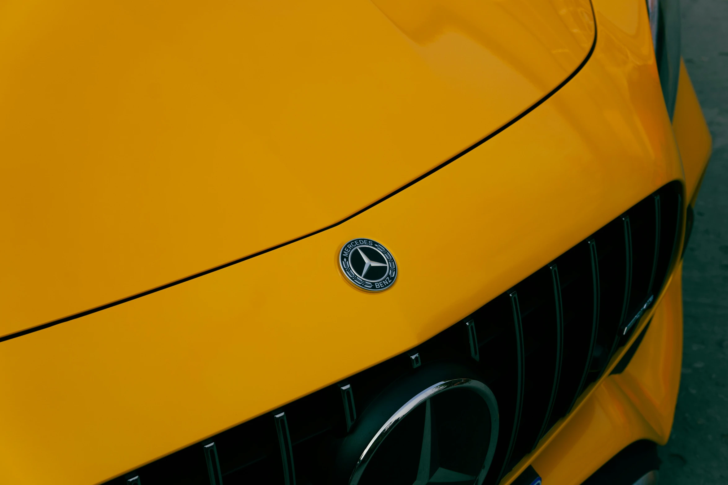 the emblem on the front of a yellow mercedes benz
