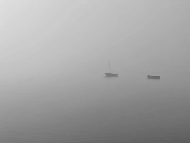 boats floating on water in fog and weather