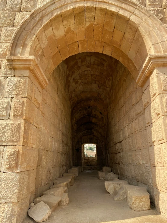 an ancient, stone tunnel with cobblestones and light colored stucco