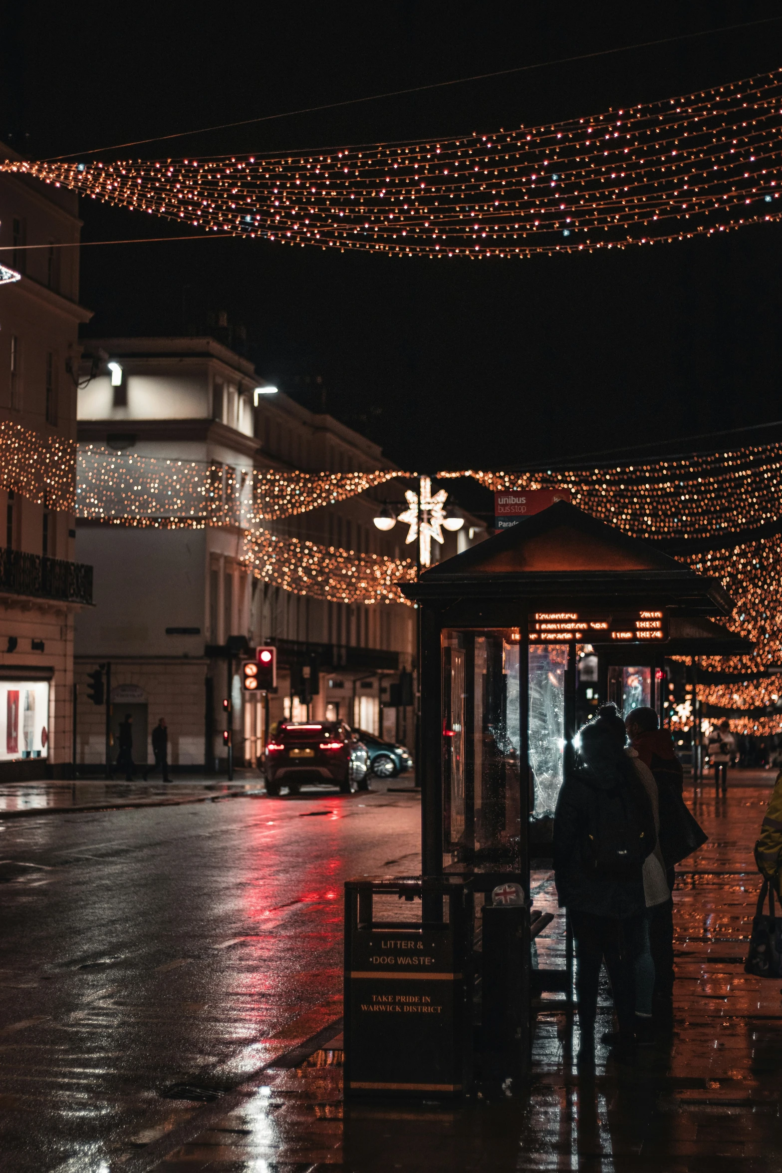 two people walking on a wet city street