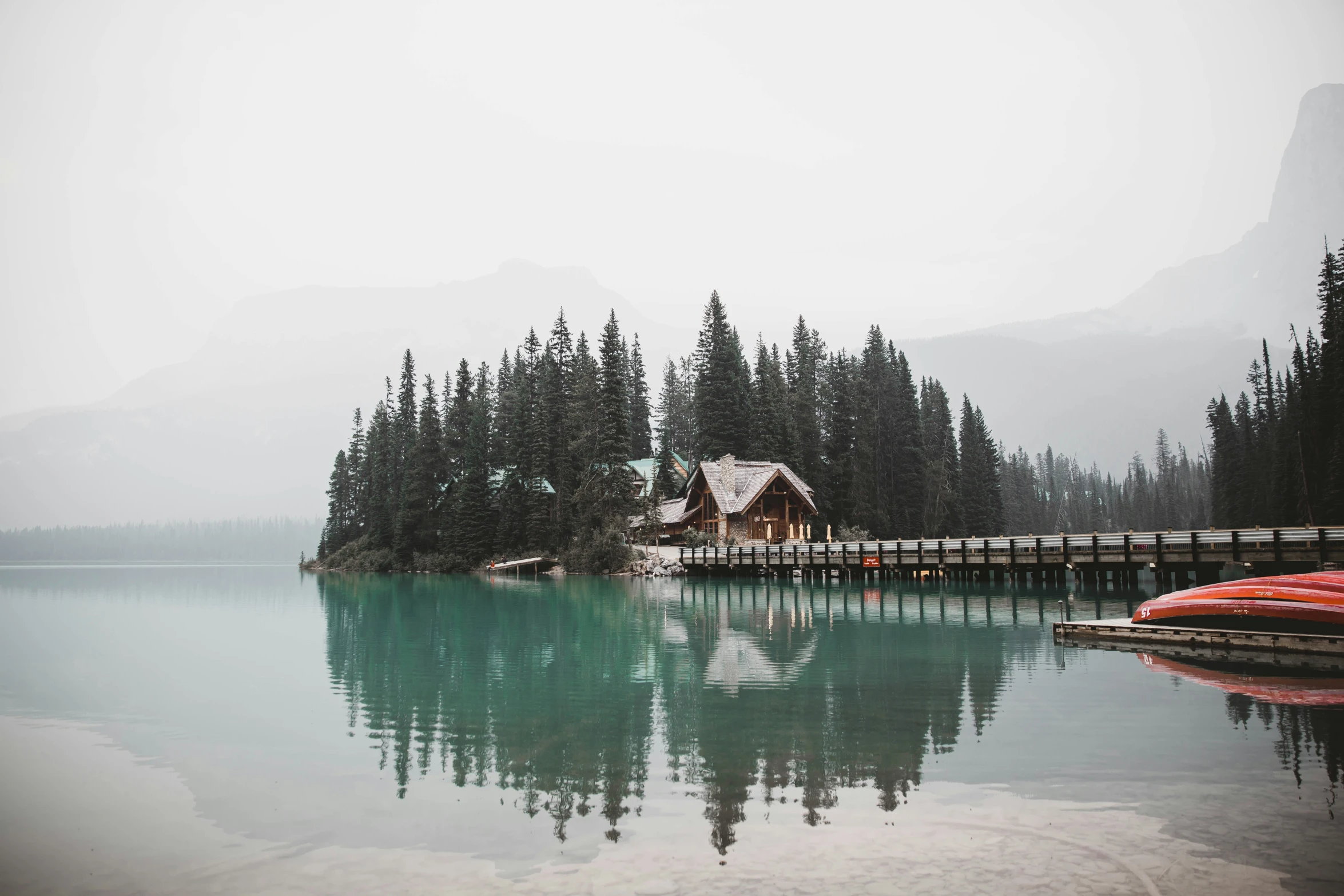 trees are in the background and a dock on the water