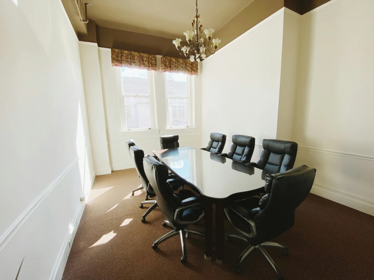an office conference room table with black leather chairs